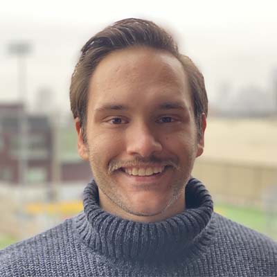 Person with a mustache and wearing a blue turtleneck