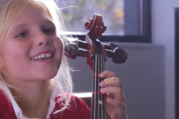 Girl playing viola and smiling