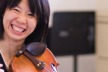 Smiling woman with violin on her shoulder
