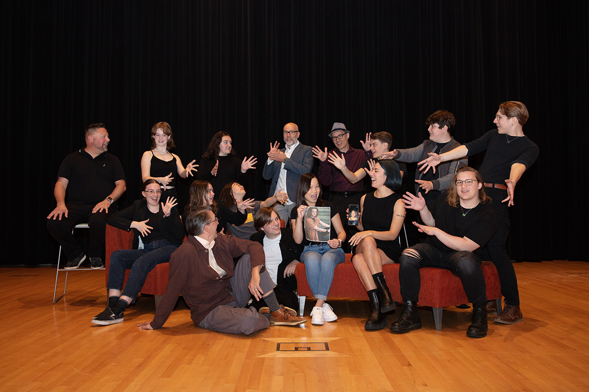 teachers and students on a stage making fun gestures