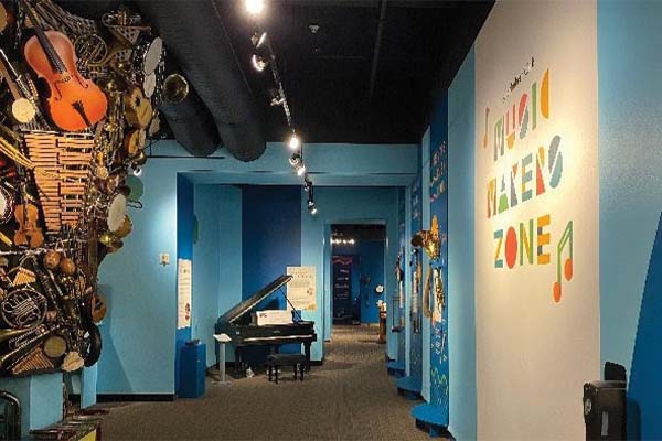 Photo of a hallway with bright blue walls and a piano at the end of the hall