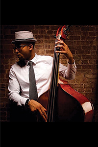 Chris standing with a bass, looking to the left