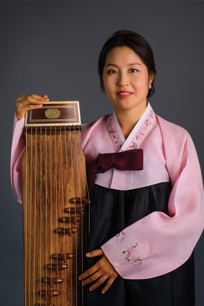 Soojin standing holding a Gayageum