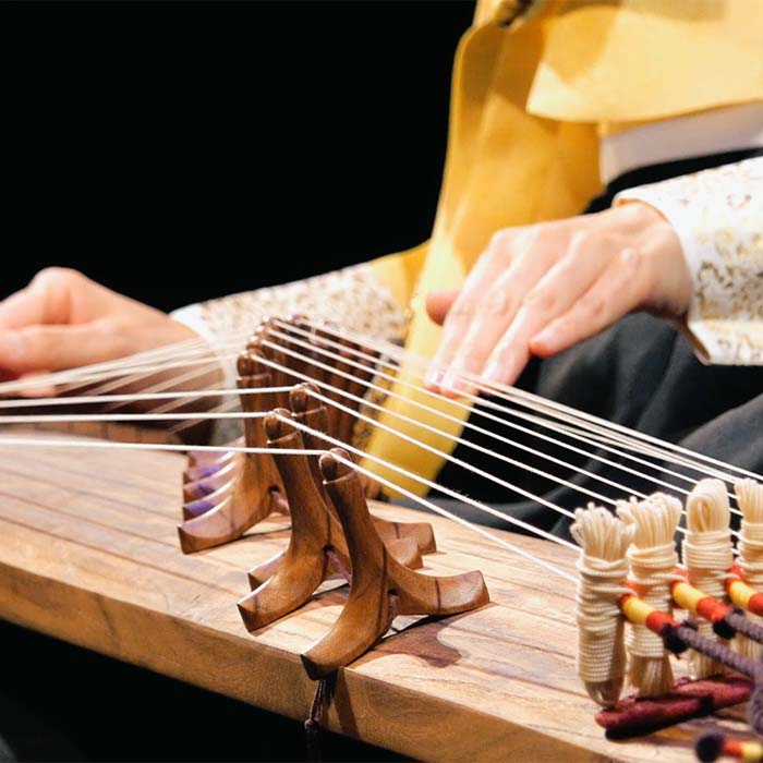 Close up photo of hands playing a gayageum