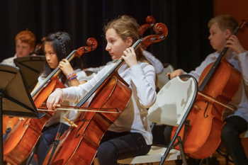 A group of students performing cello