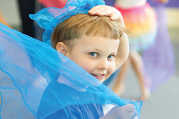 Young child playing with blue tulle