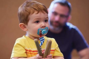 toddler holding wooden sticks