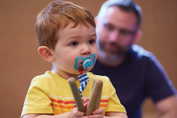 toddler holding wooden sticks