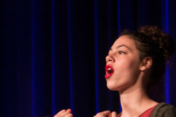 Sing view of a student singing and holding her hands in fists