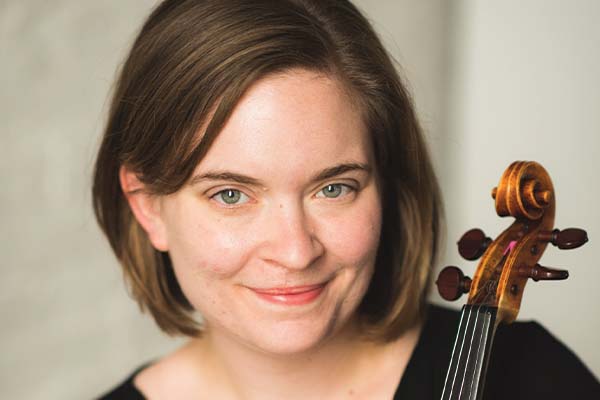 Person with short brown hair, holding a violin or viola